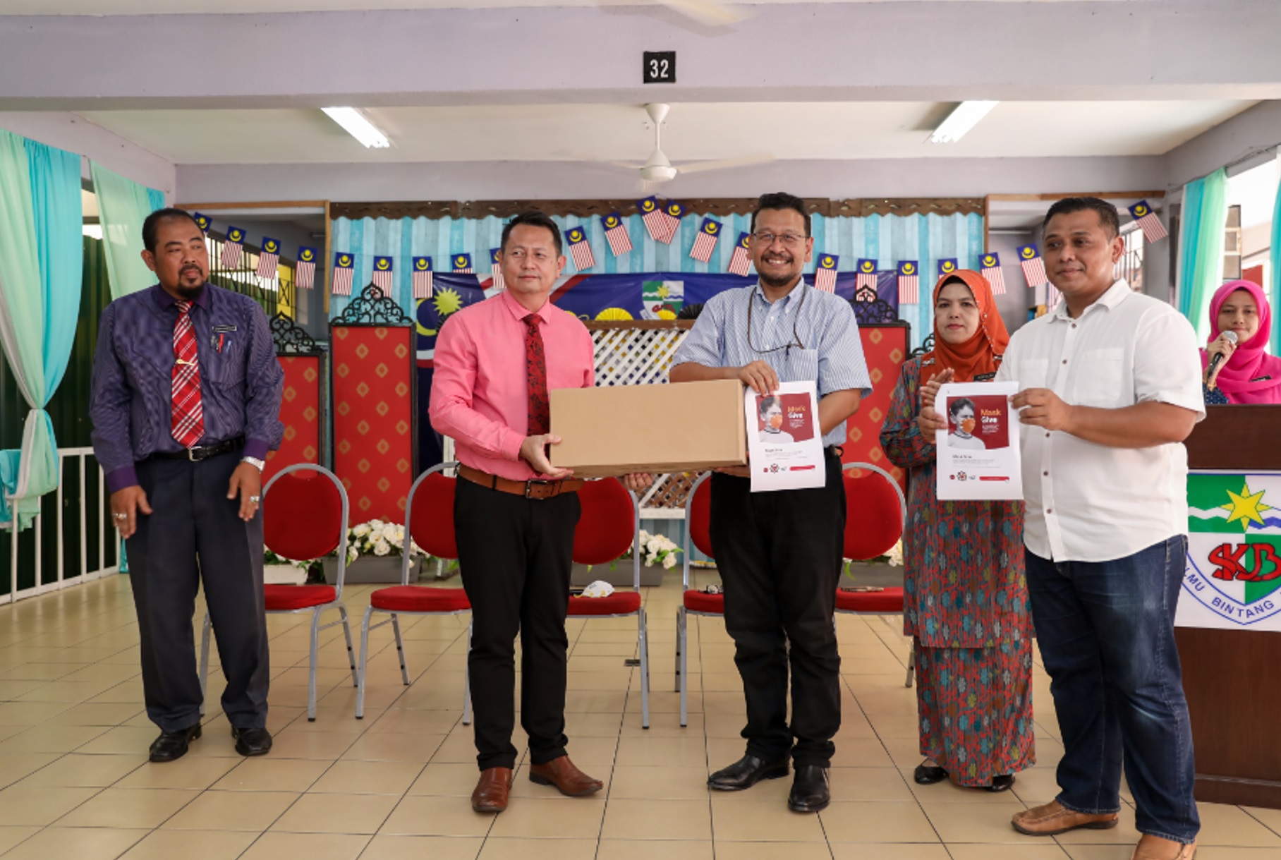 Izad Ismail Head of Corporate Responsibility and External Stakeholder Engagement TM handing over the N95 respiratory masks to Soharto Baharen, the Headmaster of SK Bangsar